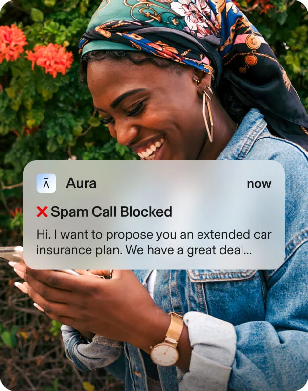Seemingly happy woman looking at her phone, next to an Aura popup that confirms blocking a spam call from Happy Insurance